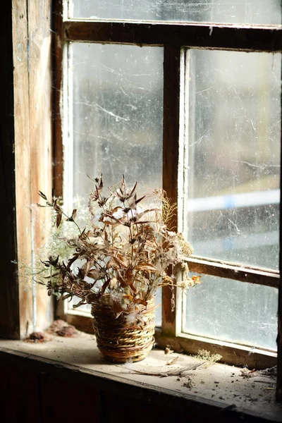 Korb mit getrockneten Blumen. Strauß getrockneter Blumen am Fenster im alten Haus. — Stockfoto