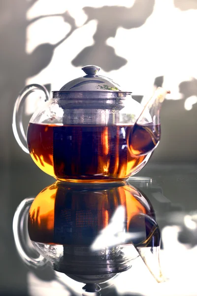 Teapot with tea standing on the table prozraznom. Glass table. Tea party . — Stock Photo, Image