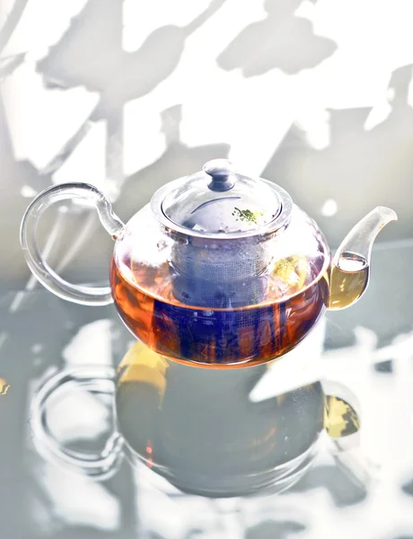 Glass teapot standing on a glass table . — Stock Photo, Image