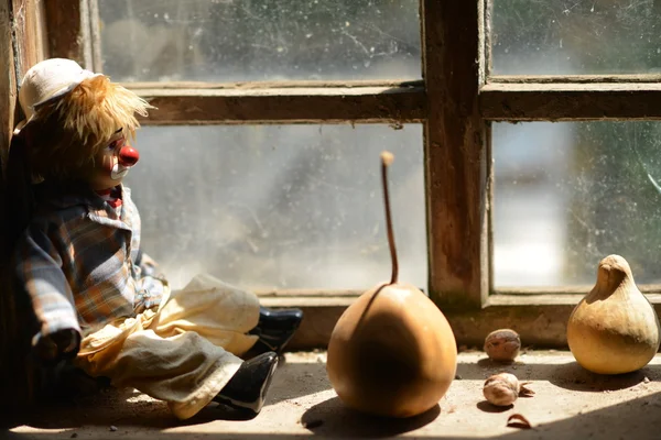 Sad clown looking through a window.