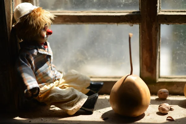 Sad clown looking through a window.