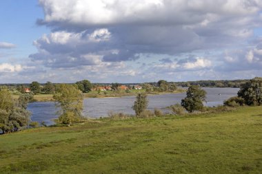 Elbe Nehri 'nin tam arkasındaki küçük köyü görüyorum. Lezbiyen, sele karşı en önemli korumadır. Evler tipik kuzey Alman tuğla ve kereste yapısını gösteriyor..