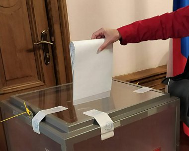Letonya, Riga. Rusya Federasyonu Devlet Duma 'sı seçimleri Letonya' daki Rus Büyükelçiliği 'nin oy kullanma merkezinde. Kadın oy veriyor..
