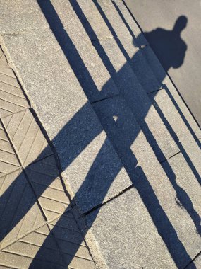 Letonya, Riga. Daugava Nehri üzerindeki köprüde bir adamın gölgesi..