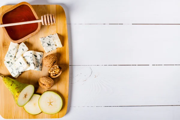 Cheese with slices of pear, nuts and honey — Stock Photo, Image