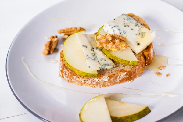 cheese with slices of pear, nuts and honey