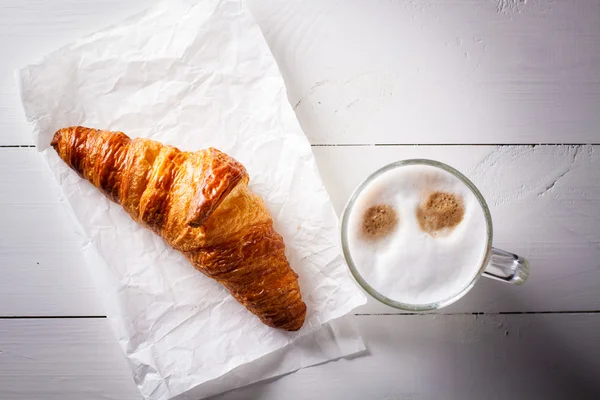 Latte macchiato koffie en croissant voor lunchtijd. — Stockfoto