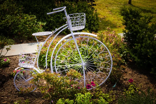 Escultura de metal de bicicleta como canteiro de flores no jardim . — Fotografia de Stock