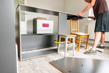 Adam çocuk odasındaki gardırobu katlıyor..