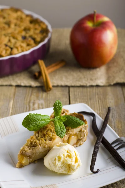 Tarta de manzana con helado, decorada con vainilla, menta y canela sobre fondo de madera . — Foto de Stock