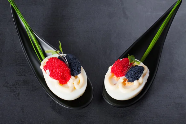 Appetizer on fingerspoon egg with caviar with copy space. — Stock Photo, Image
