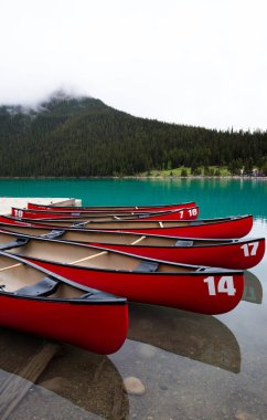 Louise gölünde kırmızı tekneler, yağmurlu ve bulutlu bir gün. Kimse.