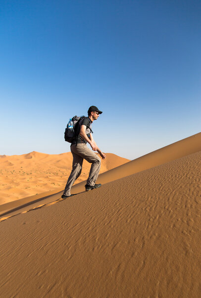 One man climbing a sand dune