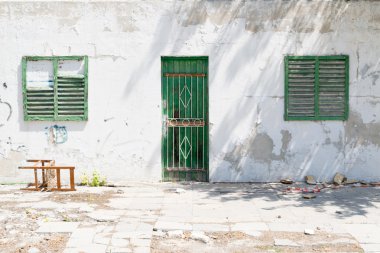 Yıpranmış bina cephesi ile yeşil Panjur