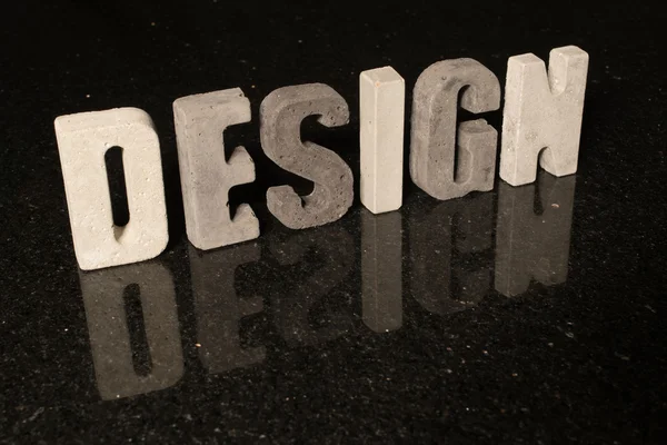 Word Design come lettere di cemento grigio su piastrelle nere — Foto Stock