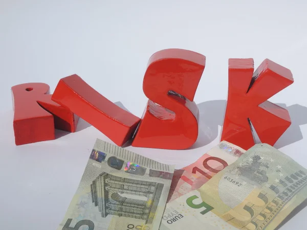 Finanční riziko ilustrované Euro bankovky a 3d písmena riziko — Stock fotografie