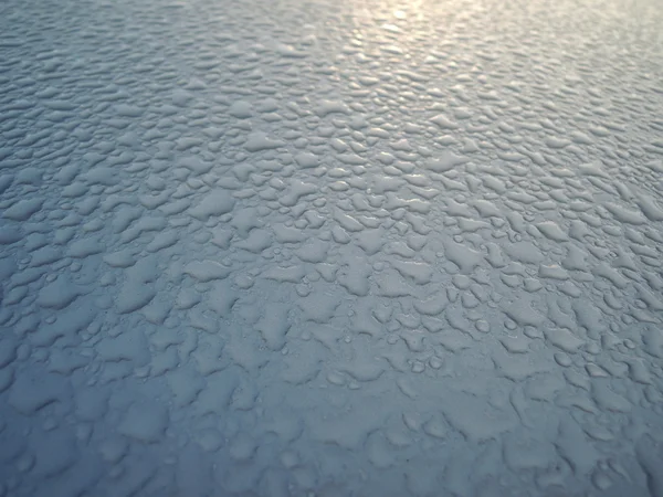 Gotas de agua en la parte superior de un coche — Foto de Stock