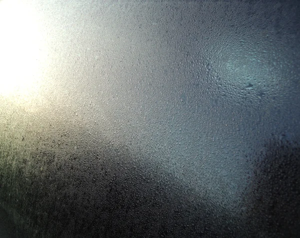 Water droplets on a window with sunlight reflection — Stock Photo, Image