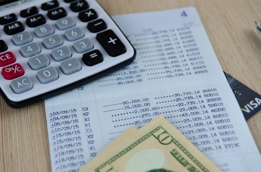 Hesap makinesi ve banka hesap cüzdanı Doları banknot ile kalem