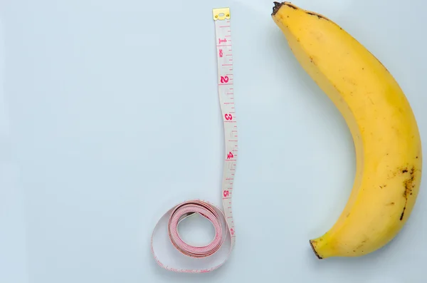 大片大片的香蕉与白色背景上卷尺 — 图库照片