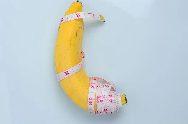 Plátano grande con cinta métrica sobre fondo blanco — Foto de Stock