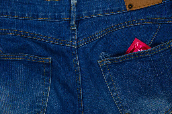 Презерватив готов к безопасному сексу на фоне джинсов
.