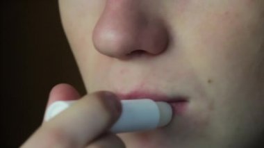 Dudak nemlendiricisi - hijyenik ruj uygulayarak genç adam. Yakın çekim