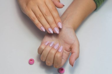 Beyaz arka planda güzel bir manikür. Uzun tırnaklı kadın elleri. Beyaz arka planda pembe manikürlü bir kızın elleri..