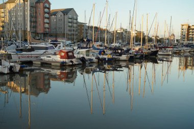 Portishead Marina 'daki derin sularda yansıması olan geniş yelkenli ve tekneler.