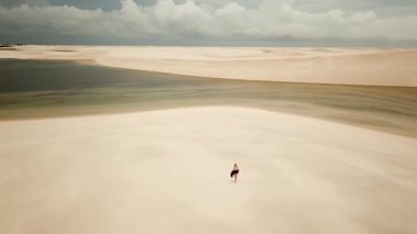 Lencois Maranhenses Ulusal Parkı kum tepeleri ve lagünlerle dolu. Rota Lagoa Azul, Maranhao, Brezilya 'ya koşan bir kız. Yüksek kalite 4k görüntü