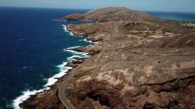 Honolulu 'nun doğu yakasındaki volkanik ve plajlı sahile yakın bir sahil yolu. Turkuaz kristal temiz okyanus ve güzel dağlar. İHA görüntüleri, Oahu Hawaii. Yüksek kalite 4k görüntü