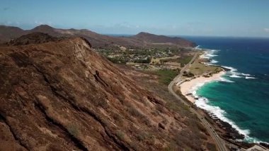 Honolulu 'nun doğu yakasındaki volkanik ve plajlı sahile yakın bir sahil yolu. Turkuaz kristal temiz okyanus ve güzel dağlar. İHA görüntüleri, Oahu Hawaii. Yüksek kalite 4k görüntü