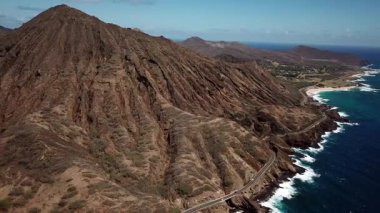 Honolulu 'nun doğu yakasındaki volkanik ve plajlı sahile yakın bir sahil yolu. Turkuaz kristal temiz okyanus ve güzel dağlar. İHA görüntüleri, Oahu Hawaii. Yüksek kalite 4k görüntü