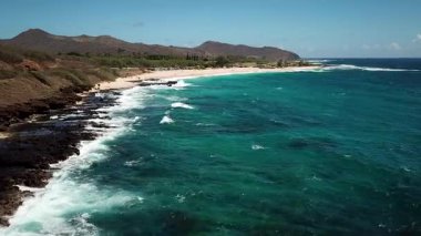 Honolulu 'nun doğu yakasındaki volkanik ve plajlı sahile yakın bir sahil yolu. Turkuaz kristal temiz okyanus ve güzel dağlar. İHA görüntüleri, Oahu Hawaii. Yüksek kalite 4k görüntü