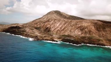 Honolulu 'nun doğu yakasındaki volkanik ve plajlı sahile yakın bir sahil yolu. Turkuaz kristal temiz okyanus ve güzel dağlar. İHA görüntüleri, Oahu Hawaii. Yüksek kalite 4k görüntü