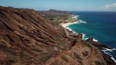 Honolulu 'nun doğu yakasındaki volkanik ve plajlı sahile yakın bir sahil yolu. Turkuaz kristal temiz okyanus ve güzel dağlar. İHA görüntüleri, Oahu Hawaii. Yüksek kalite 4k görüntü