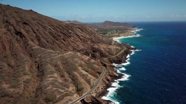 Honolulu 'nun doğu yakasındaki volkanik ve plajlı sahile yakın bir sahil yolu. Turkuaz kristal temiz okyanus ve güzel dağlar. İHA görüntüleri, Oahu Hawaii. Yüksek kalite 4k görüntü