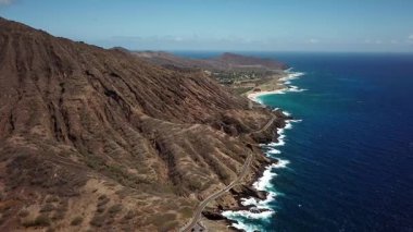 Honolulu 'nun doğu yakasındaki volkanik ve plajlı sahile yakın bir sahil yolu. Turkuaz kristal temiz okyanus ve güzel dağlar. İHA görüntüleri, Oahu Hawaii. Yüksek kalite 4k görüntü