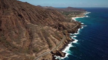 Honolulu 'nun doğu yakasındaki volkanik ve plajlı sahile yakın bir sahil yolu. Turkuaz kristal temiz okyanus ve güzel dağlar. İHA görüntüleri, Oahu Hawaii. Yüksek kalite 4k görüntü