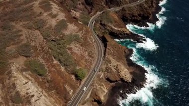 Honolulu 'nun doğu yakasındaki volkanik ve plajlı sahile yakın bir sahil yolu. Turkuaz kristal temiz okyanus ve güzel dağlar. İHA görüntüleri, Oahu Hawaii. Yüksek kalite 4k görüntü