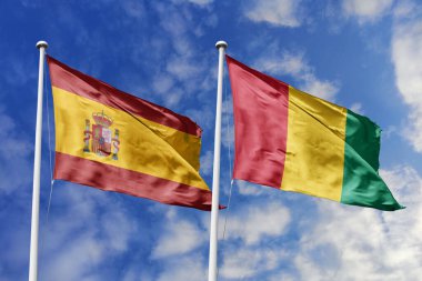 Mavi gökyüzünde dalgalanan İspanya ve Gine bayrakları diplomasiyi, ticareti, stratejik ortaklığı ve birliği simgeliyor..