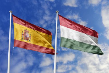 Mavi gökyüzünde dalgalanan İspanya ve Macaristan bayrakları diplomasi, ticaret, stratejik ortaklık ve birliği simgeliyor.