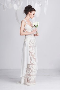 Uzun boylu ve ince genç gelin bir lüks dantel gelinlik.