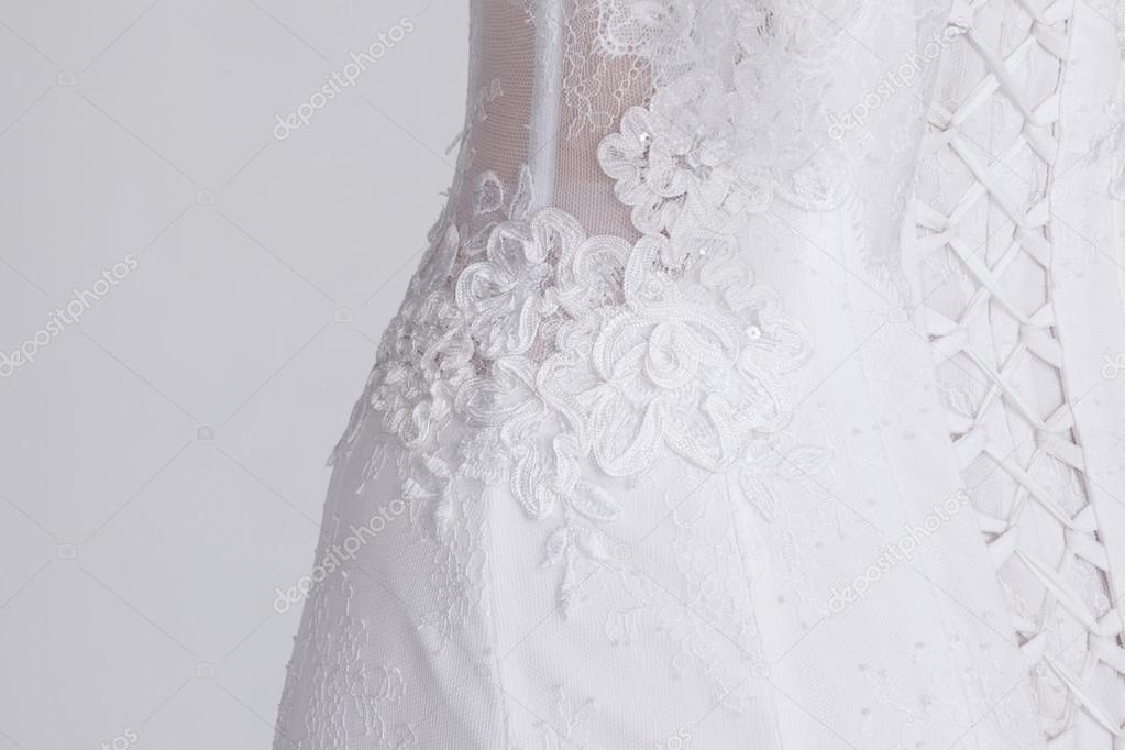 Detail of luxury expensive wedding dress. Lace, satin ribbons, expensive fabric.