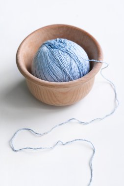 Tek mavi iplik yumağı ahşap bir kapta bir wh ayakta yatıyor