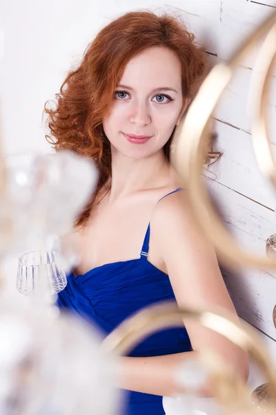 흰 나무 벽에 서 있는 파란 드레스에 젊은 여자 — 스톡 사진