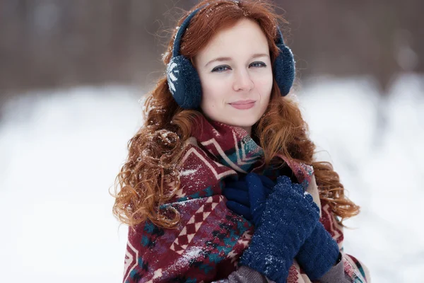 Retrato de una joven pelirroja con auriculares y guantes azules . —  Fotos de Stock