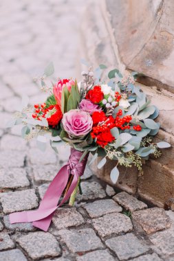 Güzel düğün buket pembe peonies ve kırmızı gül şehir merkezinde eski kaldırım üzerinde kapat