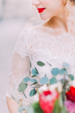 Parlak kırmızı ile güzel gelin düğün buket yakın çekim tutar dudakları