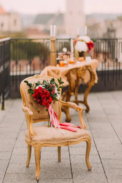 Красивий весільний букет з червоними квітами на вінтажному бежевому стільці — стокове фото